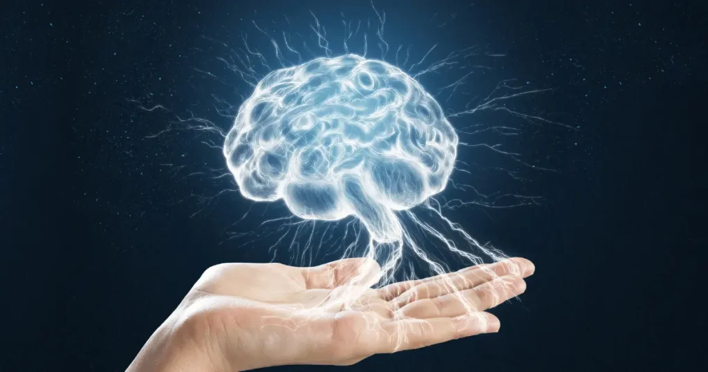 Representação digital de um cérebro luminoso flutuando sobre uma mão, simbolizando o poder da mente e os avanços da neurociência.