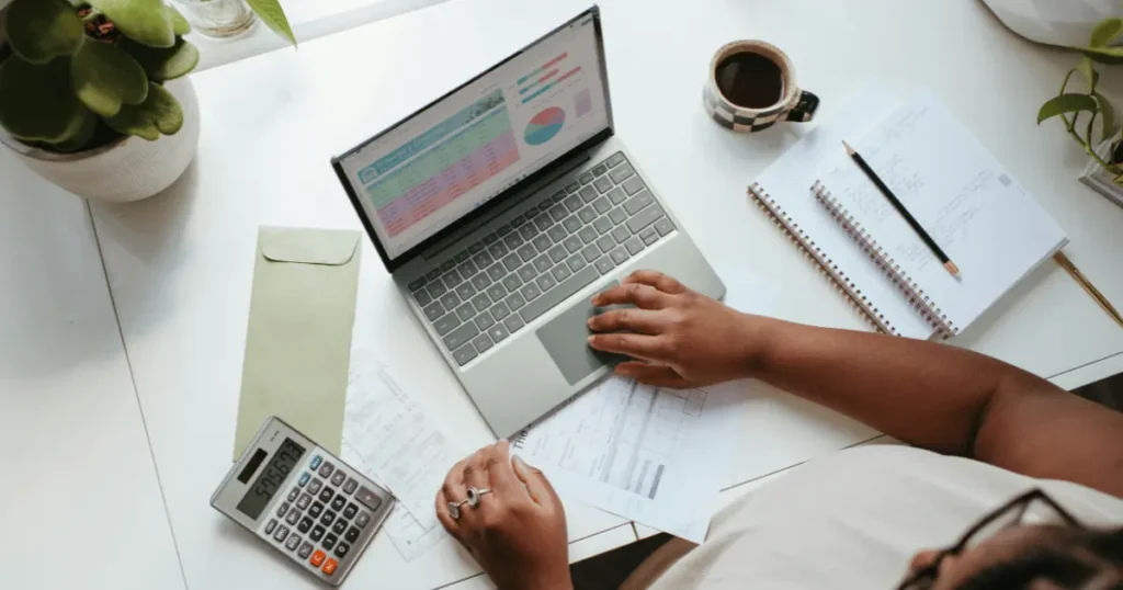 Gráficos, planilhas e anotações sobre finanças em notebook e calculadora — imagem relacionada a livros para empreendedores e gestão financeira.